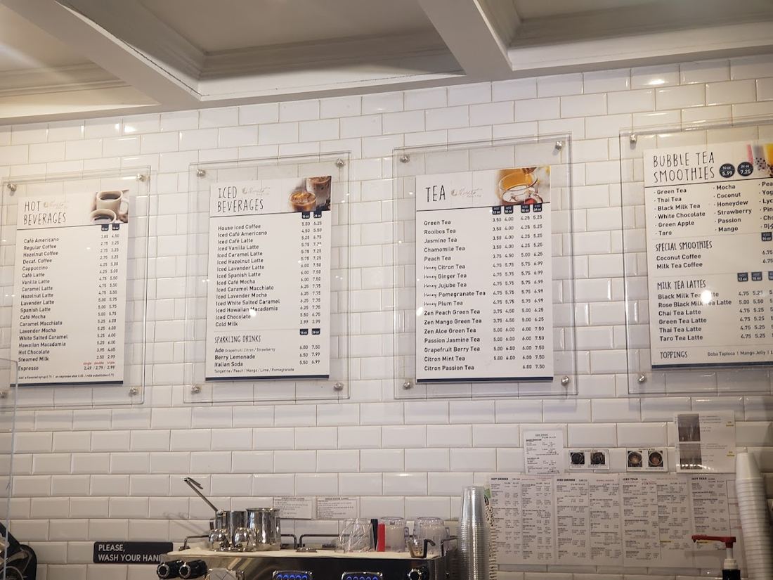 Menu boards above the counter listing hot beverages, iced beverages and teas