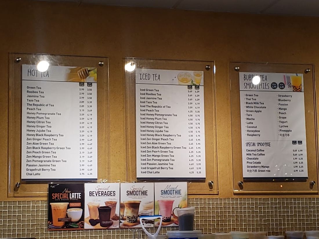 Hot tea, iced tea and bubble tea smoothie boards on the tiled wall at Mozart Bakery
